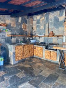 a kitchen with wooden cabinets and a sink at Cabañas Tierra Fertil in Montaña +5 photos