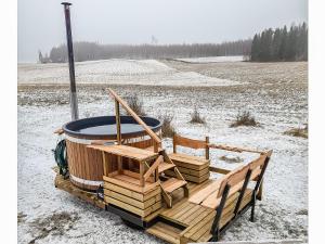 a hot tub sitting on a wooden deck in the snow at Holiday Home Tarvas by Interhome in Tarvaspohja