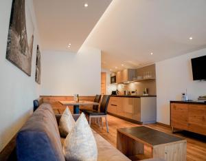 a living room with a couch and a kitchen at AKTIV Apartments by Peak Stay in Leutasch