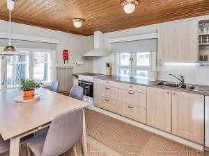 a kitchen with a wooden ceiling and a table with chairs at Holiday Home Punatulkku by Interhome in Hirsjärvi +34 photos