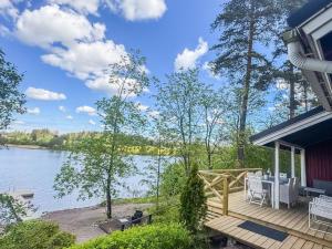 a house with a deck with a view of a lake at Holiday Home Punatulkku by Interhome in Hirsjärvi