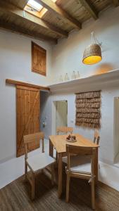 a dining room with a wooden table and two chairs at Casa do Castelo Terena in Alandroal +8 photos