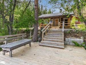 a wooden deck with a bench and a log cabin at Holiday Home Hankamaja by Interhome in Ihamaniemi