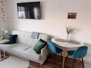 a living room with a couch and a table at Luisen City Studio Görlitz in Görlitz +3 photos