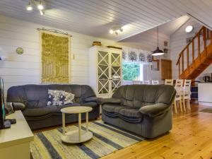 a living room with two leather couches and a table at Holiday Home Kiikkukallio by Interhome in Hankamäki