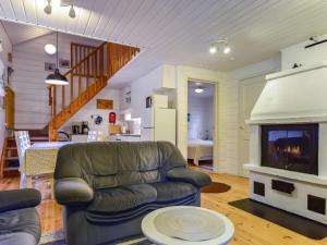a living room with a couch and a fireplace at Holiday Home Kiikkukallio by Interhome in Hankamäki