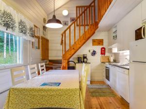 a kitchen with a table and a staircase in a tiny house at Holiday Home Kiikkukallio by Interhome in Hankamäki