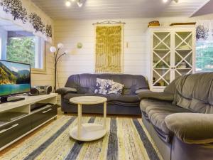 a living room with a couch and a table at Holiday Home Kiikkukallio by Interhome in Hankamäki