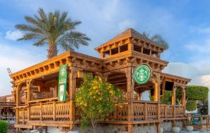 a large wooden building with a clock on it at JAZ Sharm Dreams in Sharm El Sheikh