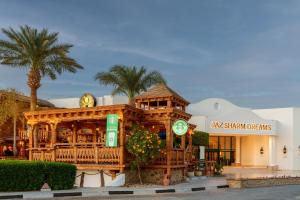 a building with a wooden building with clocks on it at JAZ Sharm Dreams in Sharm El Sheikh