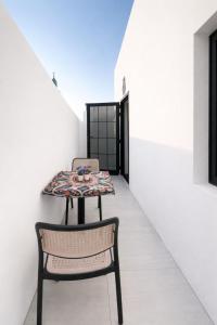 a table and chairs in a room with a white wall at Sunshine Flat in Al Khobar