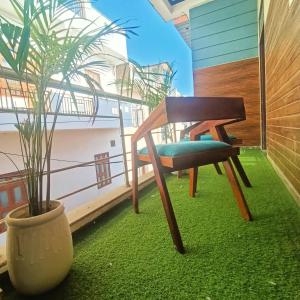 a chair on a balcony with a potted plant at hotel Atithii in Rīngas