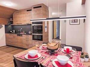 a kitchen with a table with plates and bowls at Apartment Eiger Residence Apt-A-425 by Interhome in Wengen
