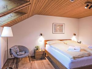a bedroom with a bed and a lamp and a chair at Apartment Eiger Residence Apt-A-425 by Interhome in Wengen