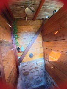 an inside view of a wooden cabin with a stone wall at Cabanas ecologicas con vista espectacular y cascada privada - Finca Qawana Ecolodge en San Carlos in Cristalina