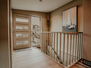 a room with a staircase and a door with a sailboat on the wall at Holiday Home De Woude by Interhome in Uitgeest