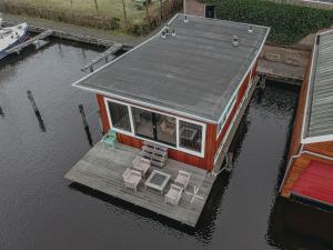 a small house on a dock in the water at Holiday Home De Woude by Interhome in Uitgeest