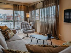 a living room with a couch and a chair and a table at Holiday Home De Woude by Interhome in Uitgeest +30 photos