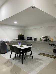 a dining room with a table and chairs in a kitchen at Mekla Hotel Studio Apartment in Gua Musang