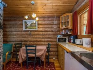 a kitchen with a table and chairs in a cabin at Holiday Home Lemmenmaja by Interhome in Paatela