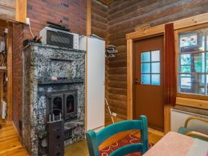 a living room with a fireplace and a tv at Holiday Home Lemmenmaja by Interhome in Paatela
