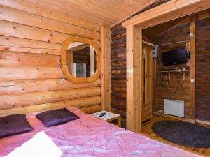 a bedroom with a bed in a log cabin at Holiday Home Lemmenmaja by Interhome in Paatela +11 photos