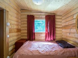 a bedroom with a bed in a log cabin at Holiday Home Lemmenmaja by Interhome in Paatela