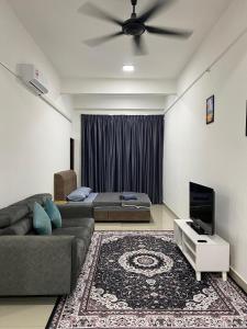 a living room with a couch and a ceiling fan at Mekla Hotel Studio Apartment in Gua Musang