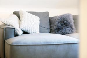 a couch with pillows on it with a pillow at LUX Ferienwohnung im Weinort Pommern an der Mosel in Pommern