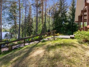 a person sitting on a bench next to a house at Holiday Home Lehtimaja by Interhome in Tiitanvaara