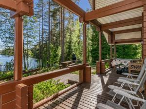 a wooden porch of a cabin with chairs and a table at Holiday Home Lehtimaja by Interhome in Tiitanvaara +20 photos