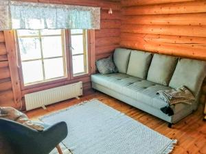 a living room with a couch in a log cabin at Holiday Home Sillankorva by Interhome in Korpijärvi