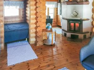 a living room with a fireplace in a log cabin at Holiday Home Sillankorva by Interhome in Korpijärvi