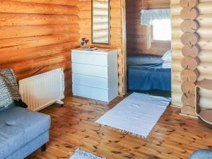 a room with a bed and a dresser in a log cabin at Holiday Home Sillankorva by Interhome in Korpijärvi +19 photos