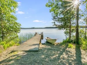 a dock with a boat next to a lake at Holiday Home Laavusranta by Interhome in Kantala