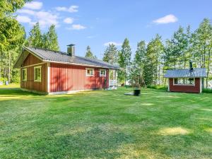 a small red house with a large yard at Holiday Home Laavusranta by Interhome in Kantala