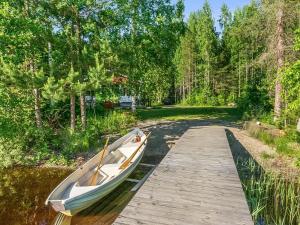 a boat is docked next to a wooden dock at Holiday Home Laavusranta by Interhome in Kantala