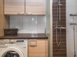 a kitchen with a washing machine and a shower at Holiday Home Villa illi by Interhome in Tahkovuori +6 photos