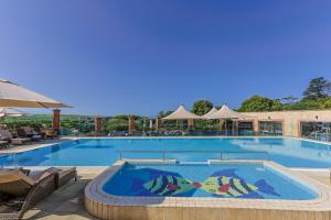 a large swimming pool with a colorful mosaic on it at Thurlestone Retreats in Thurlestone
