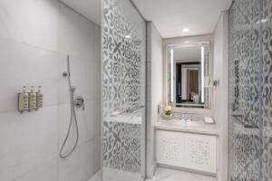 a bathroom with a shower and a sink and a mirror at Rotana Jabal Omar Makkah in Mecca +28 photos