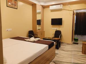 a hotel room with a bed and a flat screen tv at Hotel Mahal in Uchalon