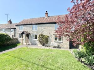 an old brick house with a lawn in front of it at April Cottage Meadow Studio in Mere +21 photos