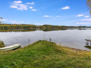 a small boat on the shore of a lake at Holiday Home Honkalinna by Interhome in Kokkosenlahti +35 photos