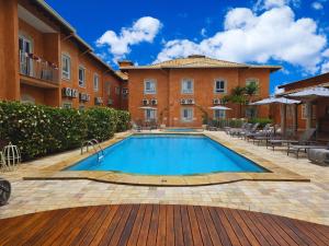 a swimming pool in front of a building at Hotel Cordialle in São Roque