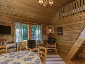 a dining room in a log cabin with a table and chairs at Holiday Home 6440 by Interhome in Pihlajaniemi +17 photos