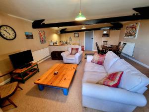 a living room with a white couch and a wooden table at Horse & Farrier Pub in Dacre
