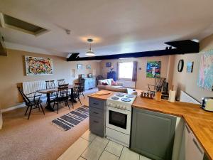 a kitchen and living room with a stove and a table at Horse & Farrier Pub in Dacre