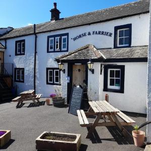 a couple of benches in front of a building at Horse & Farrier Pub in Dacre