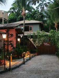 a house with a palm tree in front of it at Espaço Casa Palmar in Barra Grande