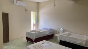 a hospital room with two beds and a chair at Hotel Renascer pojuca in Pojuca